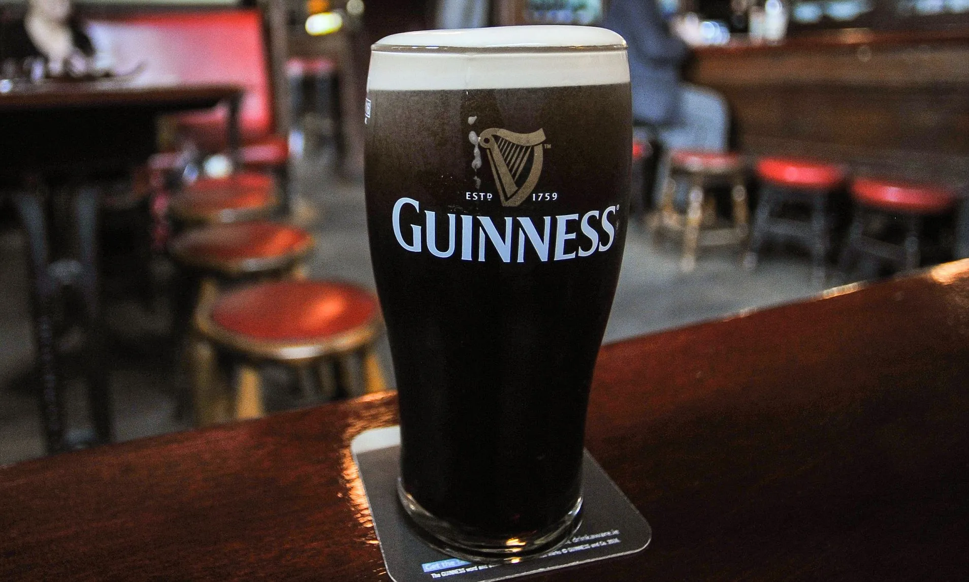 A pint of Guinness with a settled cream head on the bar