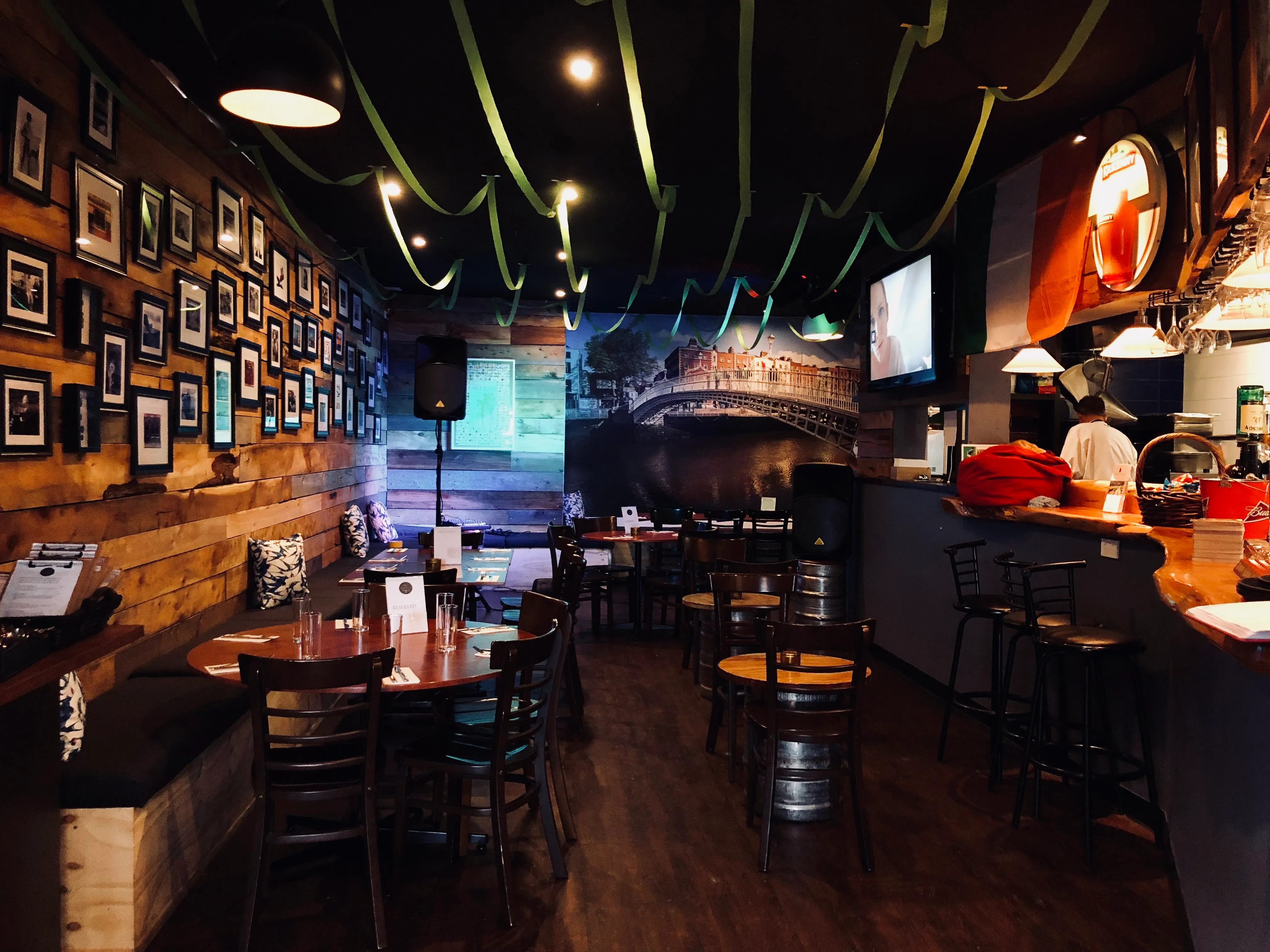 The Dubliner's timber-lined interior with a Ha'penny Bridge mural, framed photos and the bar