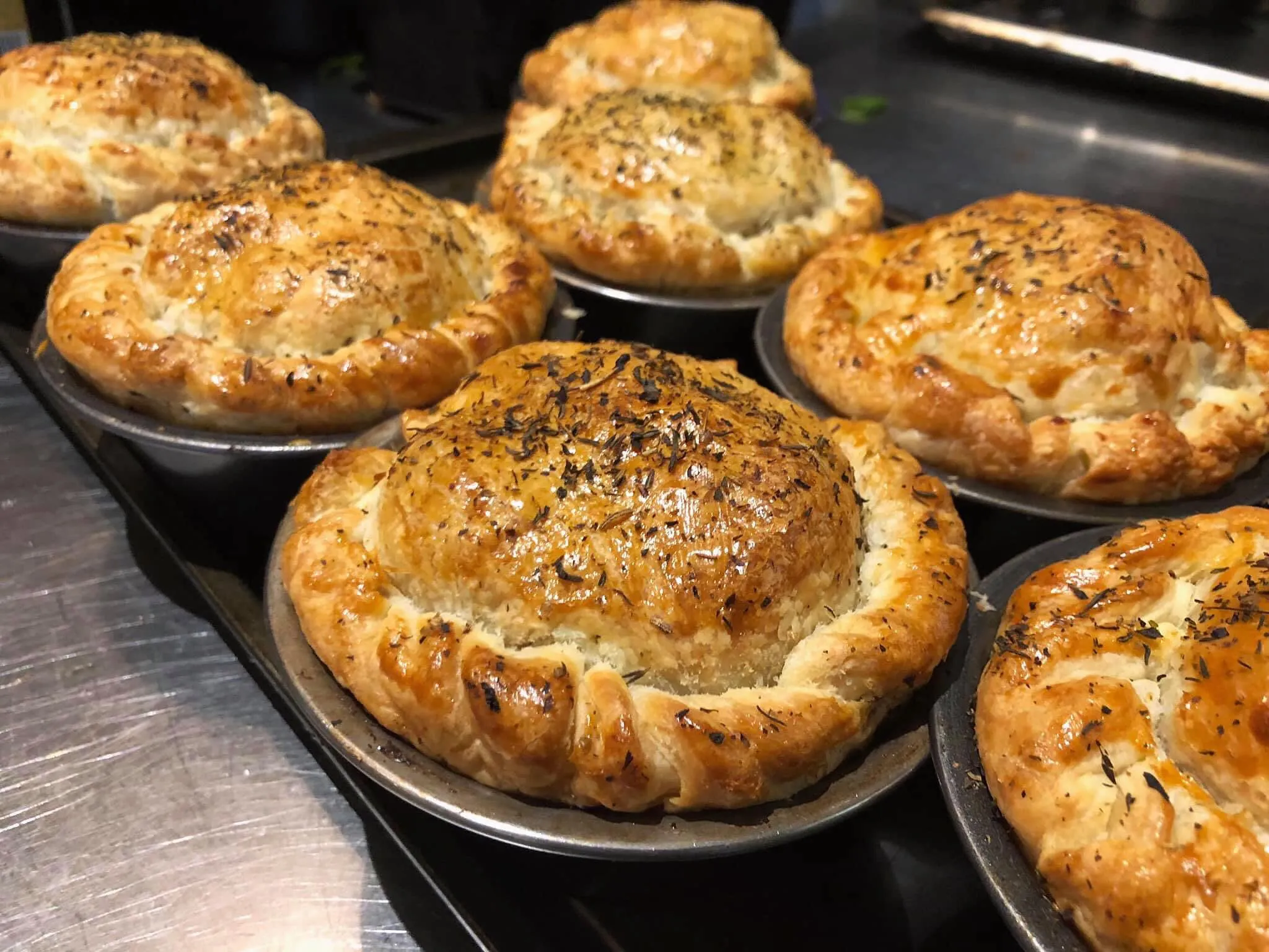 Beef & Guinness pies fresh from the oven, golden puff pastry topped with herbs