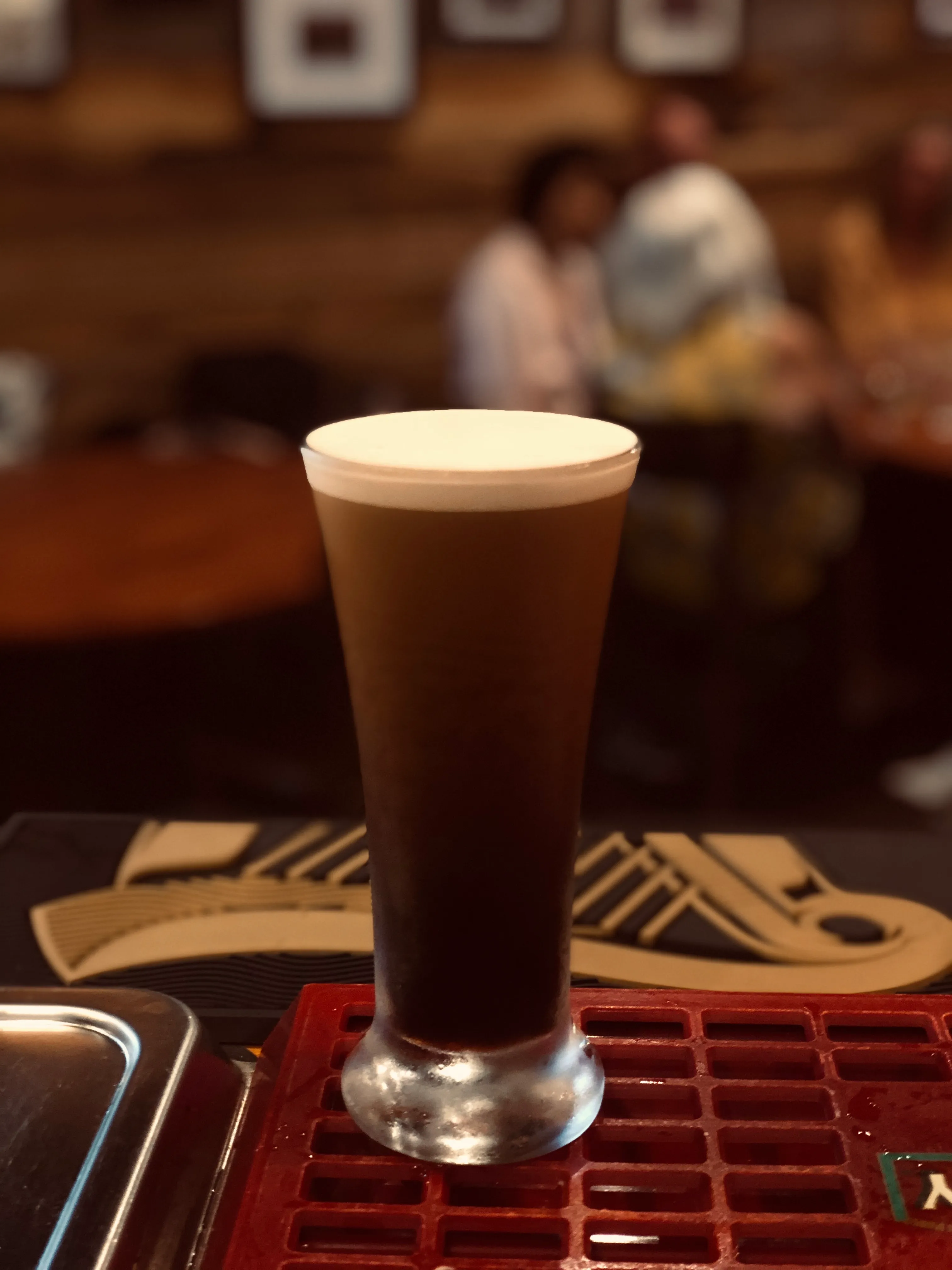 A pint of stout settling in the glass under warm, low light